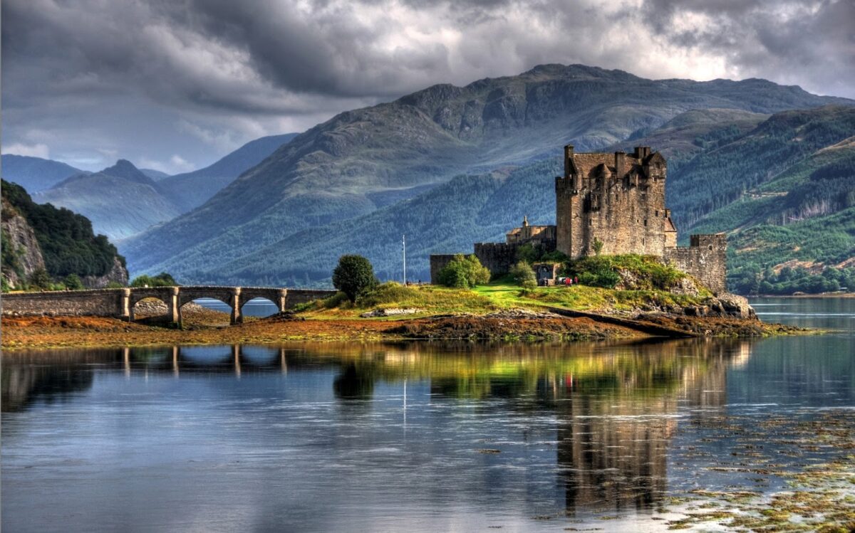 a castle rising out of the Scottish Highlands